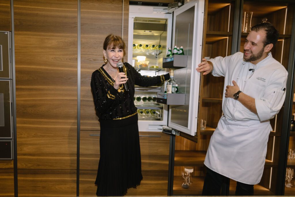 Shelby Hodge and Chef Felipe Botero playfully open the fridge in the Molteni&C kitchen at BeDesign