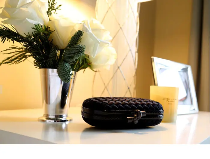 A Bottega Veneta clutch rests on her bedside table.