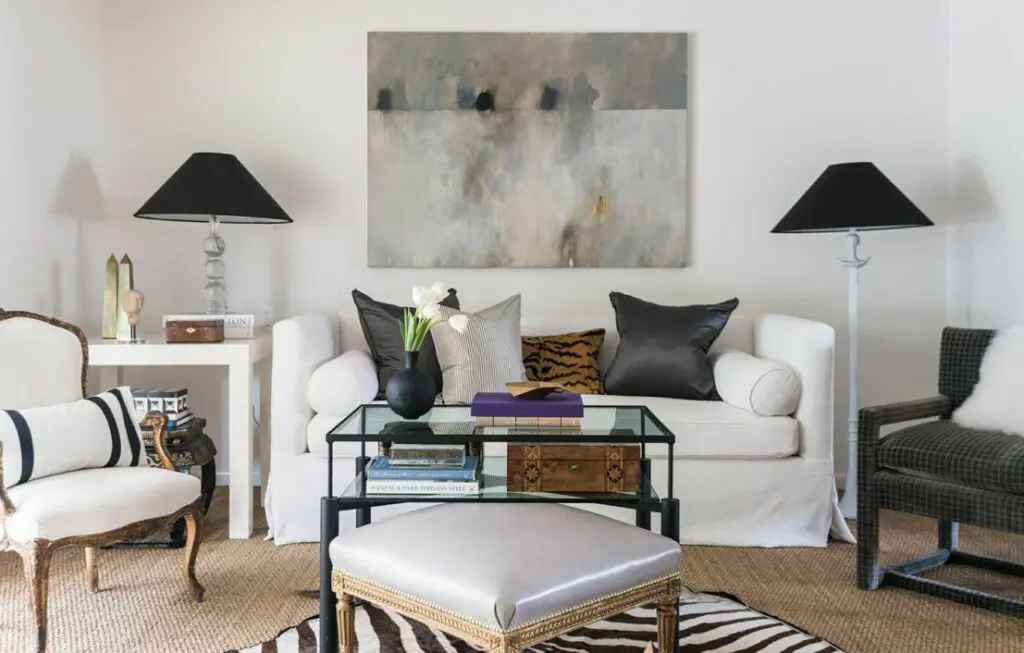 In the living room: custom upholstered sofa through Ashley Goforth, coffee table from Shabby Slips, antique gold gilt bench, zebra rug from Creative Flooring, side table from West Elm, pillows from Schumacher and Stark Fabric, artwork by Steven Seinberg through Dimmitt Contemporary and wall paint color - Sherwin Williams : Snowbound.