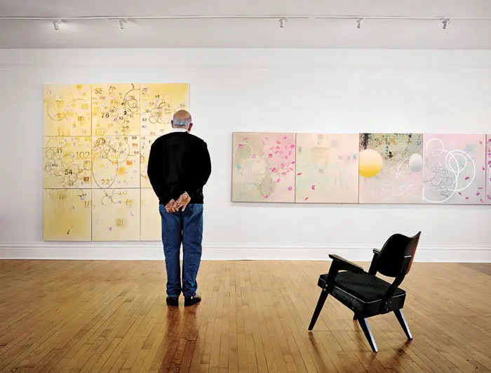 The painter contemplates two works destined for his show opening this month as Texas Gallery, “Carl Palazzolo: Recent and Remembered Work." From left: 'Orfeo,' 2014, and 'Solange' (detail of five panels), 2015. Vintage mid-century chair in foreground.