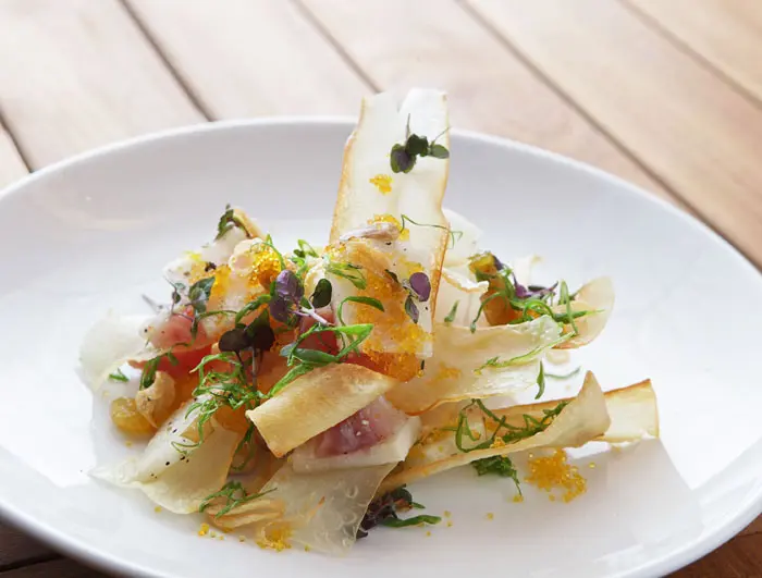 Machi Cure with smoked hamachi, yucca chips, golden raisins, and garlic brittle