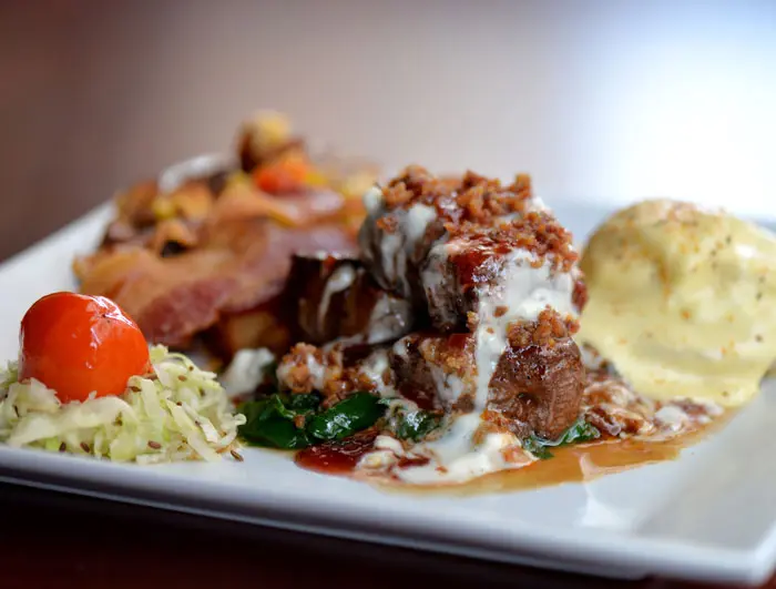 Filet Medallions & Eggs Benedict at Peli Peli. Center Cut Filet Medallions on Bed of Spinach; Eggs Benedict served with choice of Huguenot, Peppercorn,
Garlic Butter or Chakalaka Sauce. 