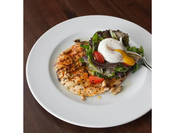 Chicken Paillard at TABLE on Post Oak. Leafy greens, croutons, poached egg, walnuts, chicken jus dressing. 