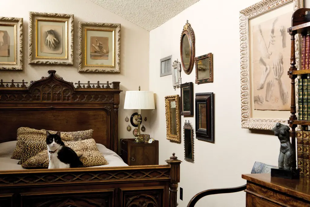 Prince’s loft bedroom with 19th-century charcoal studies of hands and feet by Italian artist Giuseppe Guzzardi. “Fannie” sits on a French Gothic Revival bed. At right, a collection of antique mirrors. The
bronze female nude is by Texas artist Charles Umlauf.