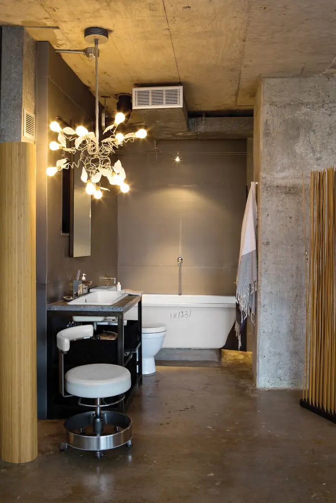 Like the entire apartment, even the bath area doesn’t
have a door. The walls, ceiling and floor have been left in raw concrete. Bamboo-sticks screen from Kuhl-Linscomb. Zuma tub. Ingo Maurer chandelier. Metalwork in the bath and throughout the house is custom-made by George Sacaris Studio.