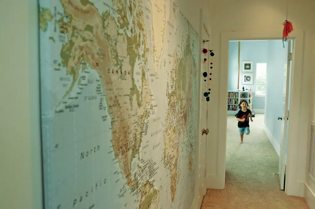 Large wall map from IKEA shows where the family lives and travels. The children made the yarn baubles.