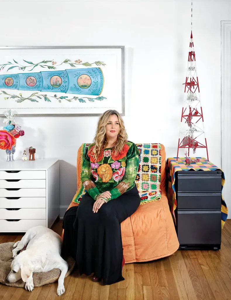 Amber Eagle in her living room with Lula. She wears a huipil garment — sewn by women from the Tehuantepec region — indicative of her passion for Mexican artisanship.