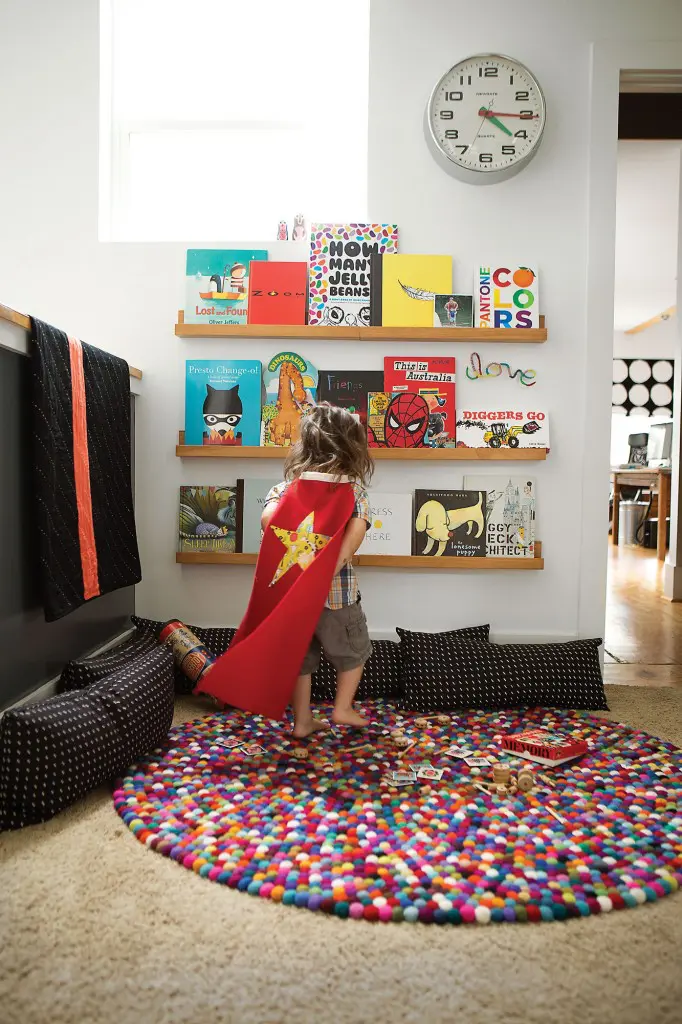 In a cozy space at the top of the stairway, the hand-made quilt is by friend Ebony Porter of Campfire Quilts. Newgate wall clock from West Elm. Straight
and Narrow book ledges from Land of Nod. Black-and-white pillows from Unison. Round felt-ball rug from Yummi Shop on
Etsy. Ingela P Arrhenius Memory Game. Vintage wooden Tinkertoy set from Jill’s childhood.
