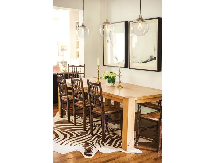 In the dining area, a Crate & Barrel Big Sur table is attended by chairs that belonged to Paula's mother. West Elm pendants. Zebra-print cowhide rug.