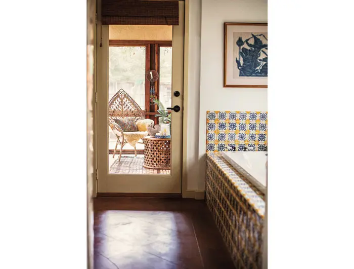 The colorful tiles in the master bath, which looks into the screened-in porch, were already in place when the Minnises moved in. Vintage artwork.