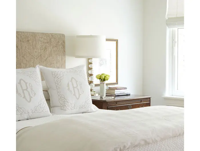 In the bedroom, the headboard is custom designed by Joe Don Watts. The monogrammed embroidered pillows are custom from Peacock Alley. Juliet matelassé from Peacock Alley. Baker lamp. Early lithograph by Marc Chagall. The antique vase was hand painted in gold leaf by Mary Ella’s grandmother. The Chippendale chest belongs to John Bitzer.