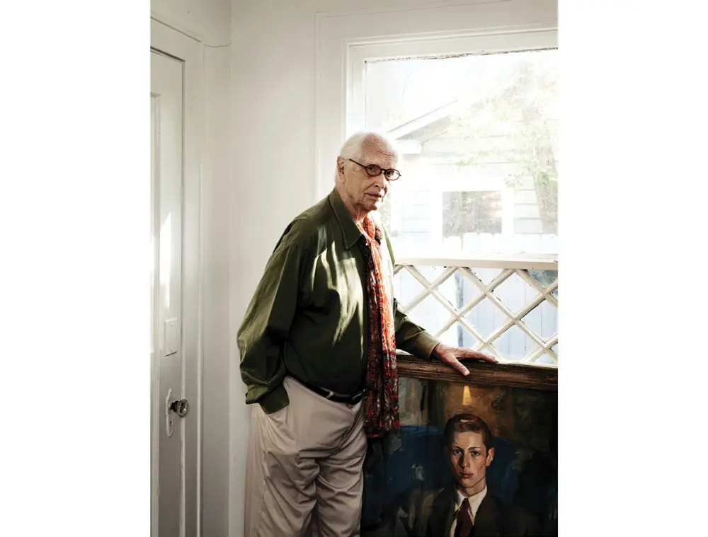 Fred Baldwin with a portrait of himself at age 18, painted by American artist Louis Betts.