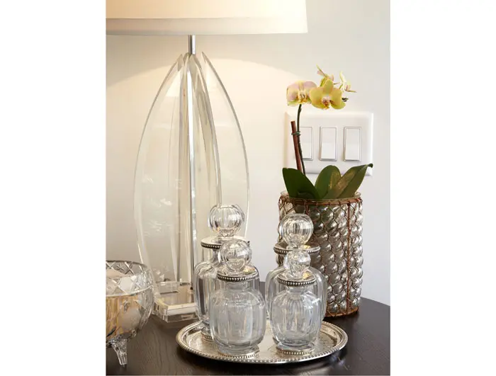The midcentury Lucite lamp is an antiques store find. The crystal and silver decanters are from a Paris flea market. The vase is from Cebolla Fine Flowers.