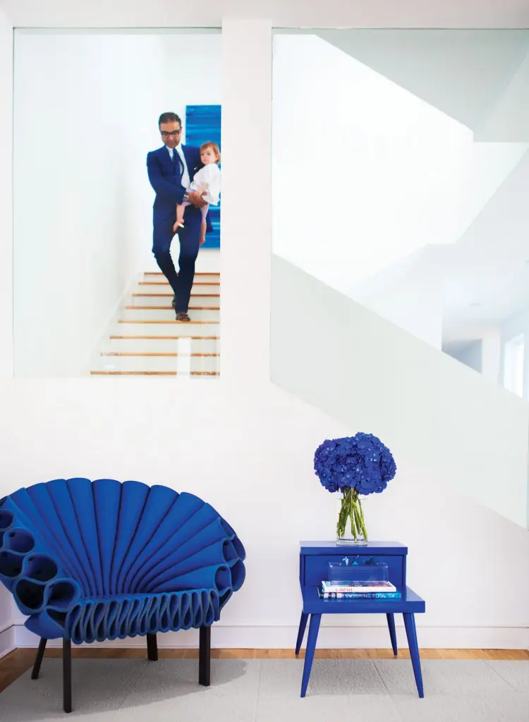 Ed and Everleigh Shaikh. Artwork in the background is by Christopher Martin. Felt Peacock chair by Dror Benshetrit for Cappellini, from Scott + Cooner. Vintage table painted cobalt.