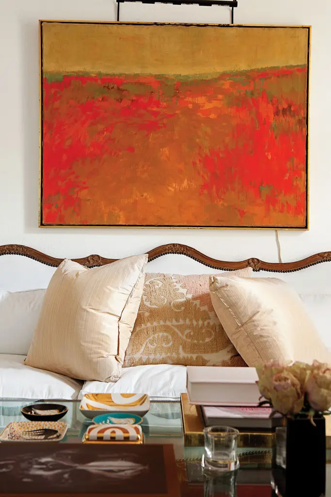 In the salon, an oil painting from the estate of Herb Wells hangs above an 18th-century French Louis XIV sofa from James Powell, Austin, covered in white cotton. Pillows in pink strie silk by Rose Tarlow from George Cameron Nash. Vintage textile pillow from Thompson Hanson. Wayland Gregory porcelain ashtrays and box from Sloan/Hall.