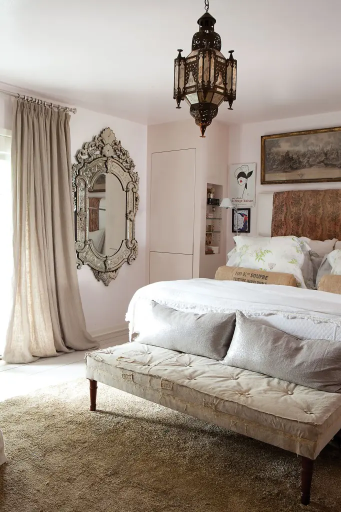 Cathy Echols' master bedroom with antique Venetian mirror and Moroccan light fixture, and the palest of pink walls. 