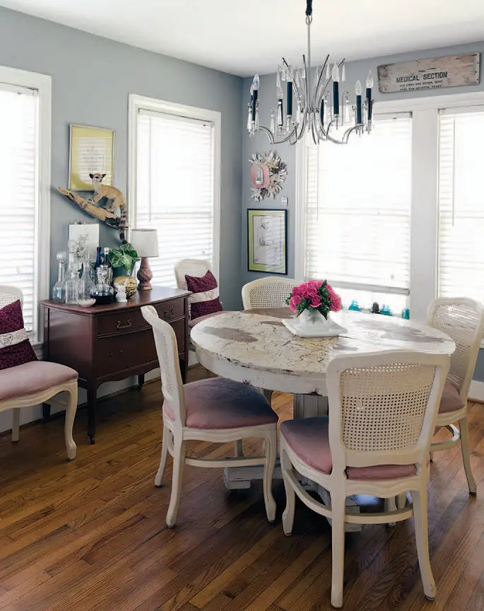 Vintage German Art Deco crystal chandelier hangs above a dining-room table
and chest inherited from Sensabaugh’s grandparents. Vintage cane-back chairs from a Houston estate sale. Antique medical sign from Fort Sam Houston. Flowers by Sensabaugh.