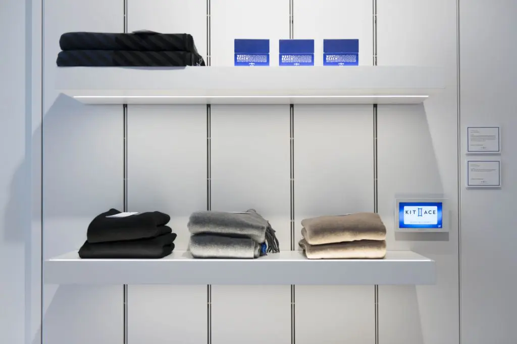 Cashmere scarves and candles line the Kit and Ace entrance. 