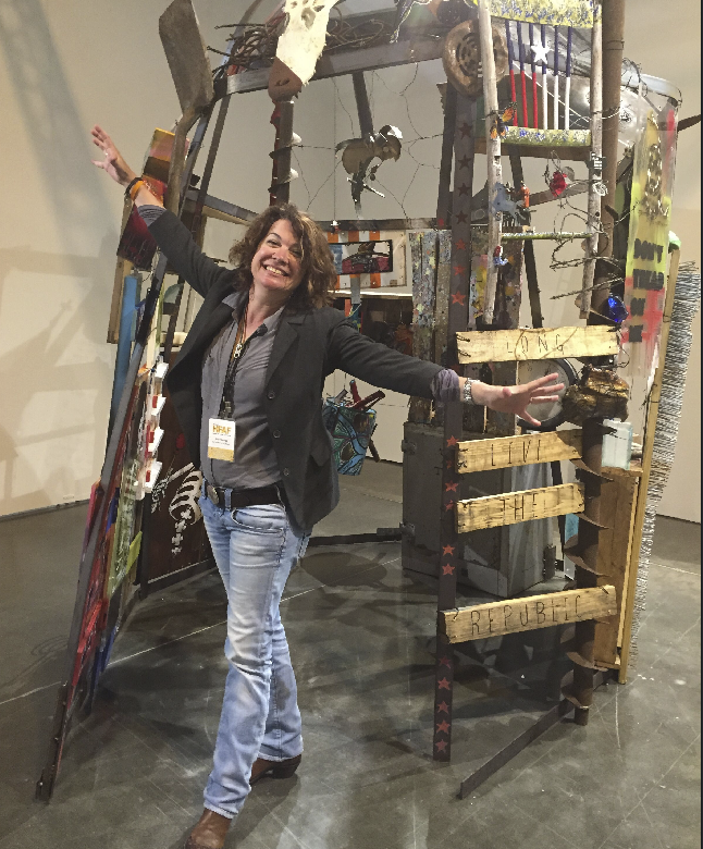 Katy Contemporary Arts Museum director Ana Villaronga-Roman in the KCAM's booth, featuring a community sculpture. 
(Photo by Nancy Gutierrez.)