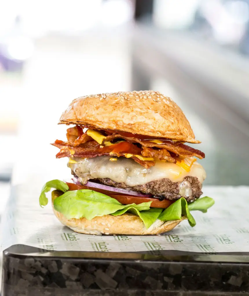 Rico's bacon cheeseburger is topped with cheese, crispy bacon, lettuce, tomatoes, onions, pickles, ketchup and mustard. 