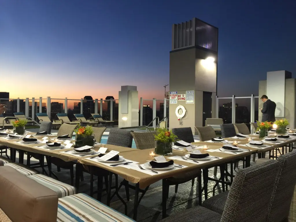 A beautiful sunset bathes the FEED Supper tablescape at Skyhouse River Oaks. 