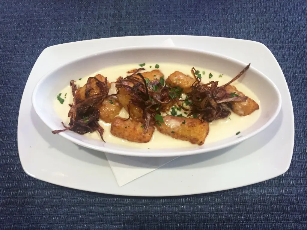 The Del's gnocchi tots are served in a cheddar and ale fondue, then topped with fried onions. 