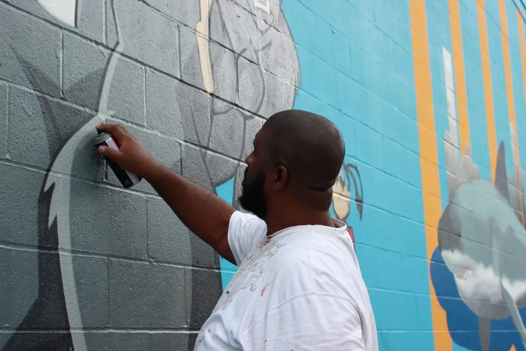 Deck WGF works on creatures in his mural. (300 N. York St.)