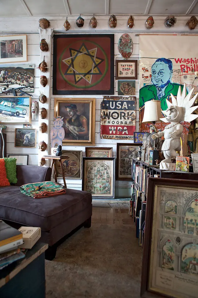 Upstairs in casa Webb
with the wall of art by
greats such as Reverend
Swearingen, David Bates
and Tim Kerr, as well as
prized carved coconut
heads, Masonic art and
a fave vintage clown
canvas.