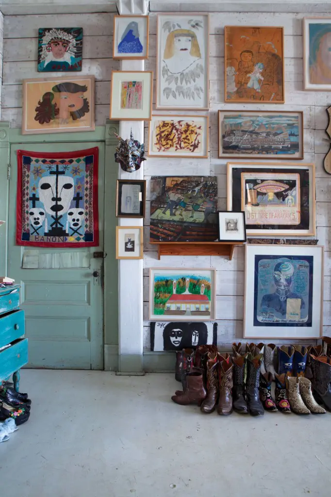 The couple’s bedroom melds the art of cowboy boots with visionary works by talents including iconic Beat writer William Burroughs.