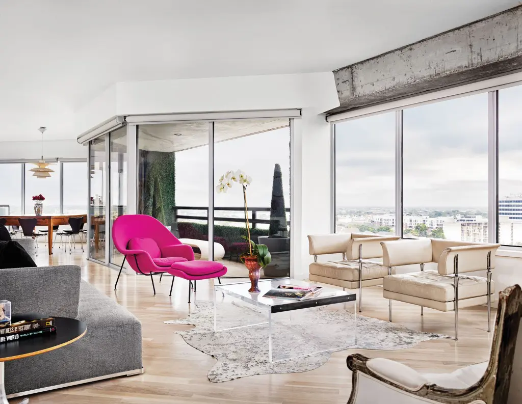 Vintage fuchsia Knoll Womb chair. B&B Italia sofa. Vintage
Plexiglas and steel coffee table from Found. Silvered cowhide rug from Vieux. On the terrace, Philippe Starck chaise. Foliage and topiaries are faux ivy.