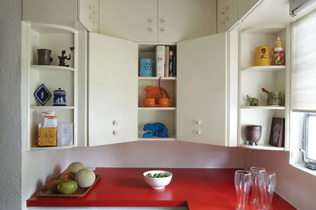 Koush refurbished the original steel cabinets in the kitchen and paired them with a new red Formica countertop.