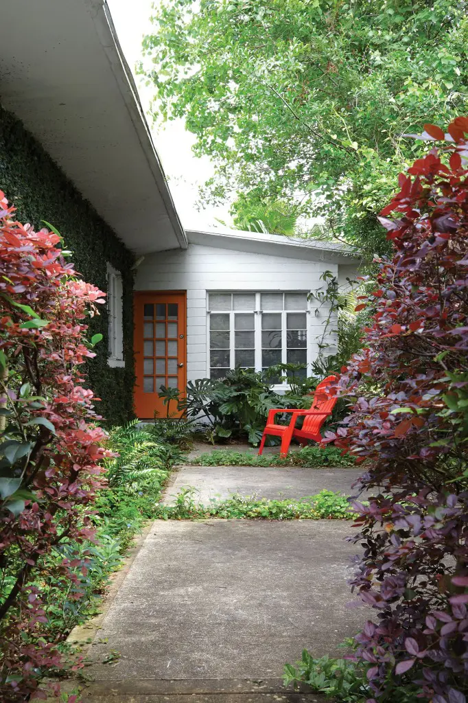 A quiet side patio is shaded by volunteer trees.  