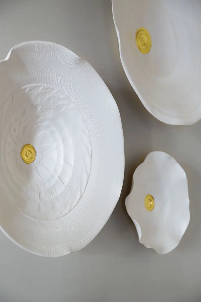 After installing a Lucrecia Waggoner installation in a project, Looke knew she wanted to start her own collection. This set of three porcelain pieces shine in the living room. At Laura Rathe Fine Art.