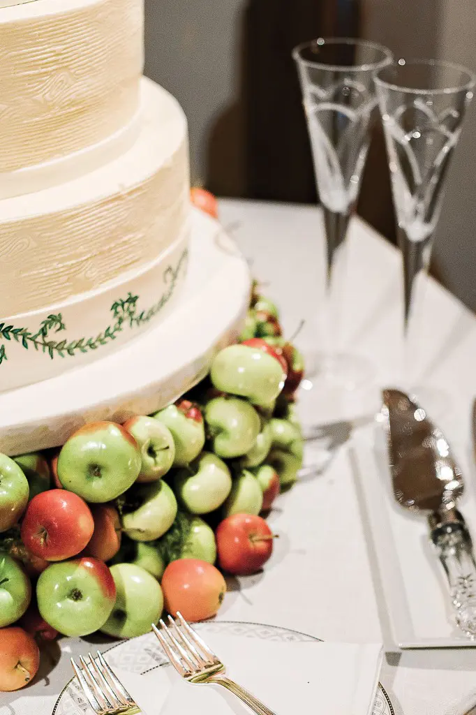 The wedding cake made by Who Made the Cake sat on a plate of miniature apples. 