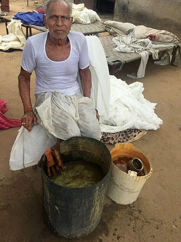 It takes a village: In the printing community of Bagru, India, many artisans play a role in the printing process. Here, one of the expert hand dyers mixes a vat of dye (sometimes using natural dyes from the earth like mustard from flowers, pomegranate or turmeric) to obtain the right shade.