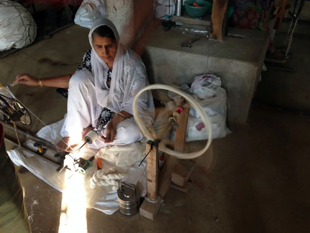 After yarn has been saturated with a paste made of potatoes or rice starch to protect it during the weaving process, it is wound by hand onto bobbins for the looms.