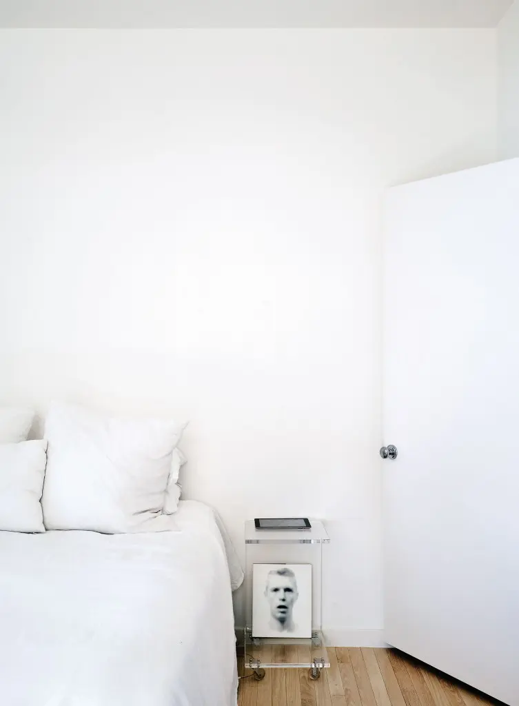 In Davis’ bedroom, white is the leitmotif. The space
is painted in the cloud-like shade of Silver Lining by
Pratt & Lambert. “I consulted with designer Margaret
Naeve of M. Naeve regarding the intimate details of
the space,” says Davis. The nightstand is an acrylic
C table. Bedside reading is a volume on artist Bill Jacobson, its cover one of the photographer’s eerie early-1990s portraits that reference the AIDS crisis.