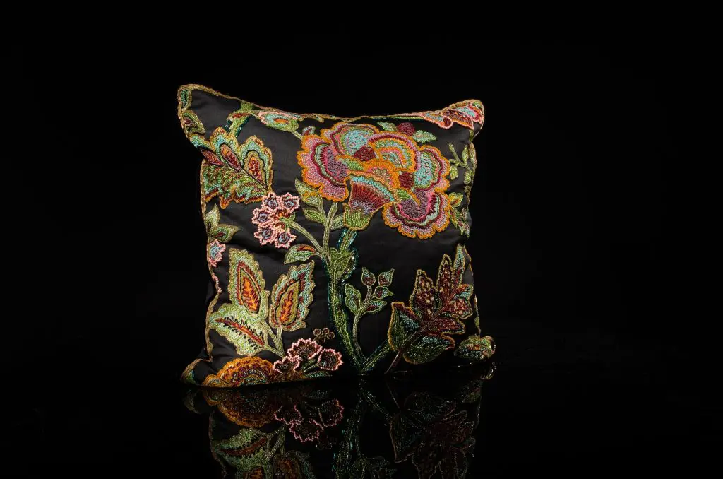 Encrusted Czech glass beads on rainbow floral with jet black fabric; burnt gold metal and silk border braid detail, black velvet welting; charcoal cashmere back with wide French ribbon detail, $2,500