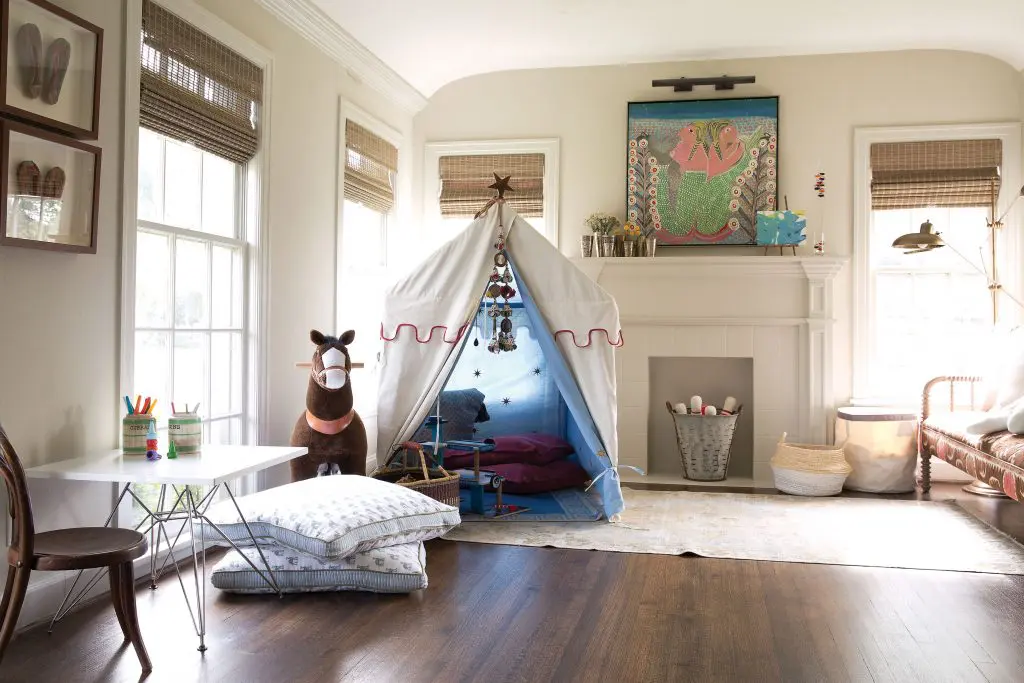 Barton’s living room functions as a playroom for her young boys. Mela & Roam’s Arabian Nights tent. Haitian folk art painting over the mantel. In front of the nonfunctioning fireplace, bowling pins are positioned in lieu of firewood.