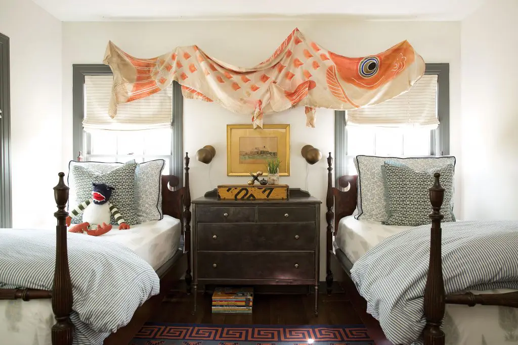 Japanese carp flag found in Round Top hangs over antique beds in son Ory’s room. The 1930s steel Simmons dresser was a gift from a client.