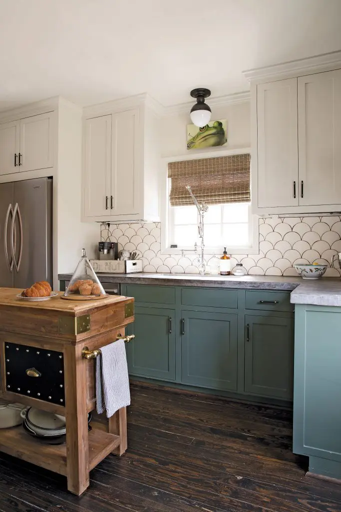 Barton fully renovated the kitchen with two-tone cabinets (lowers in Sherwin Williams Rosemary; uppers in Benjamin Moore Hazy Skies) and concrete counters with Tabarka Studio’s hand-painted terra-cotta tile backsplash.