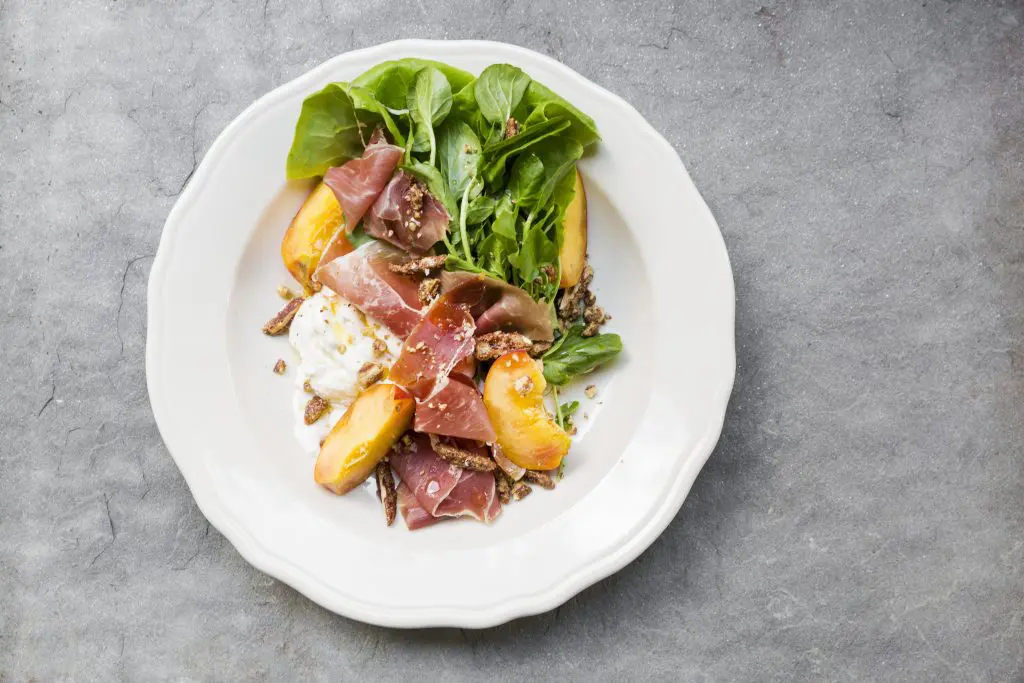 Burrata salad served with proscuitto, peaches and fresh basil