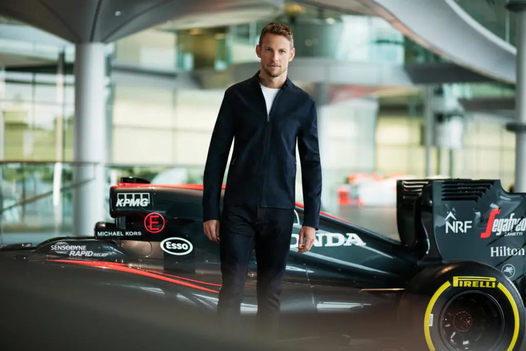 Jenson Button strikes a pose next to the new McLaren/Michael Kors race car.