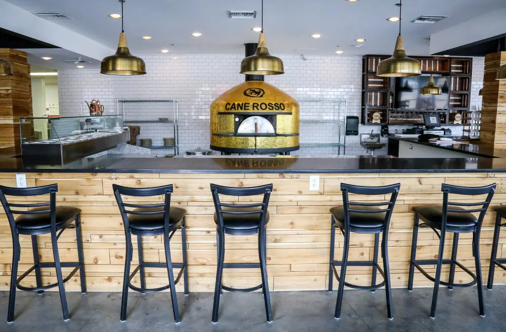 The gold-tiled Stefano Ferrara pizza oven sits front and center amid Cane Rosso's pizza bar. 
