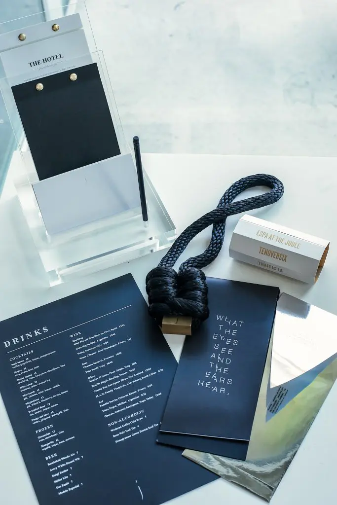 The Joule's in-room compendium, do-not-disturb sign, menu, gift card holder, and invitation for The Eye Ball