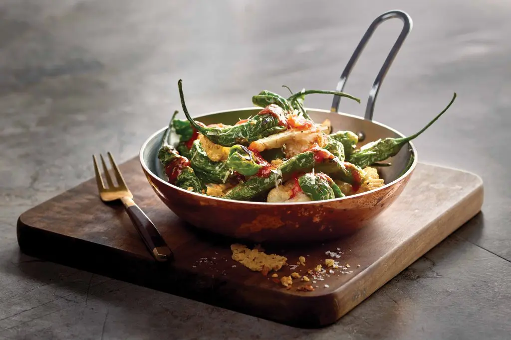 Grotto puts an Italian spin on shisito peppers, tossing them with cauliflower, parmigiana reggiano, and Calabrian chili drizzle. 