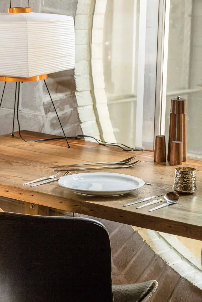 The kitchen table designed by Zemanek from salvaged wood from the previous home on the lot, Arne Jacobsen flatware, Tapio Wirkkala hand-hammered sterling silver cup, and a Paul
Evans and Phillip Lloyd Powell shaker set.