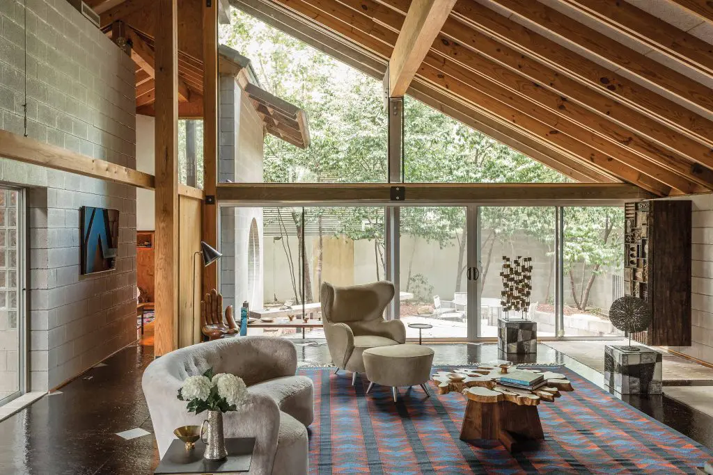 A long open hallway is anchored by a table by
George Nakashima — a masterwork in complete old-growth rosewood — ringed by Nakashima Conoid dining chairs. To the right, a pass through to the kitchen, and a series of circular Asian-inspired features based on Chinese moon gates. Dining room carpet from Swedish weaver Marta Maas-Fjetterstrom.