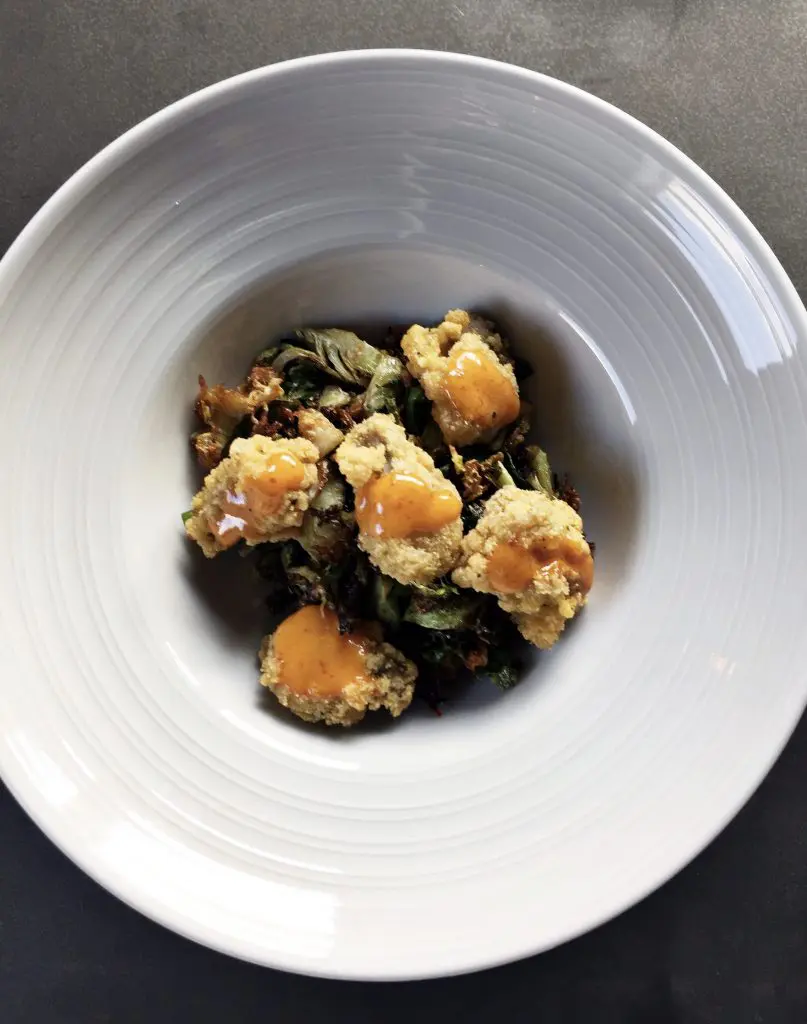 Get your seafood fixe with Field & Tides' fried oysters and Brussels sprouts served with a chili honey glaze. 