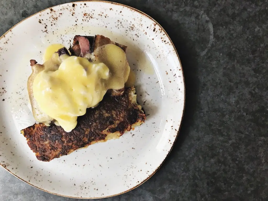Poached eggs are served over savory pork belly at State Fare. 